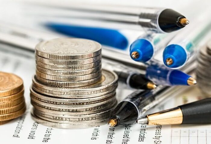 piles of coins and pens on paperwork