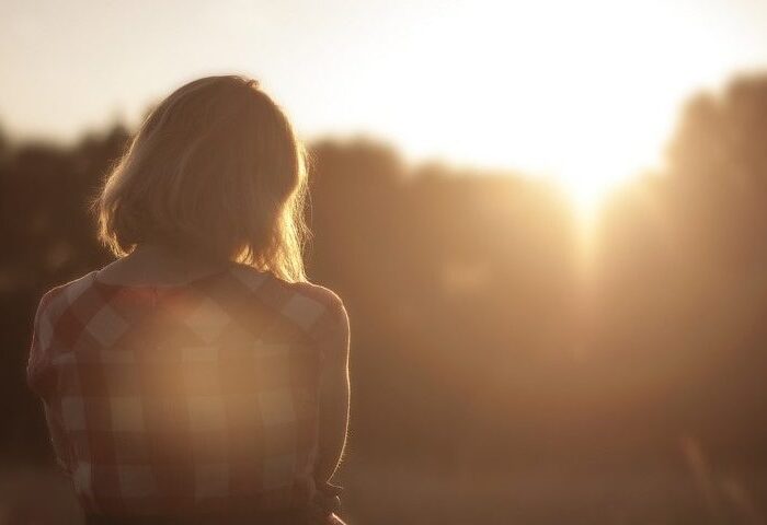 woman sat during sun set