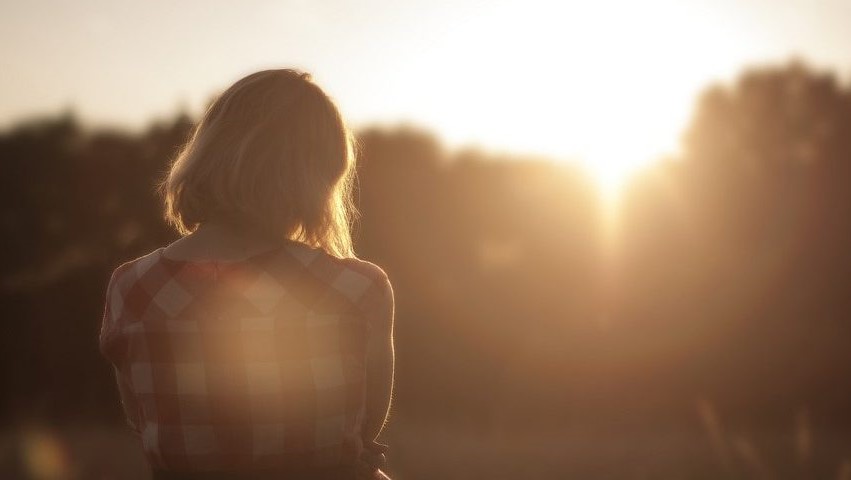 woman sat during sun set