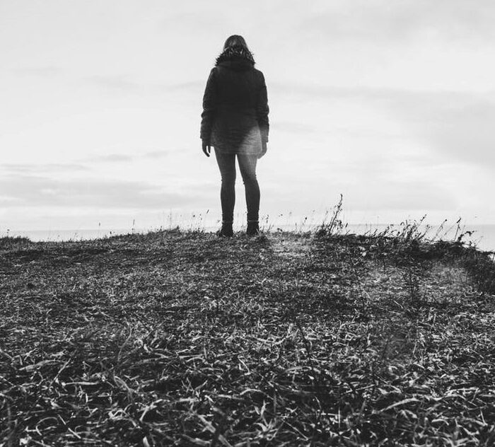 Black and white figure looking out to sea