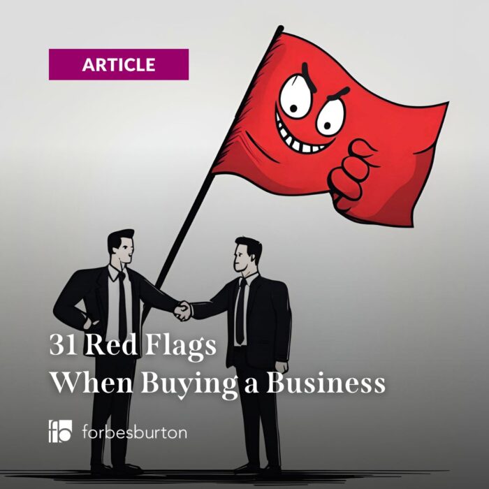 businessmen shaking hands with grinning evil red flags when buying a business