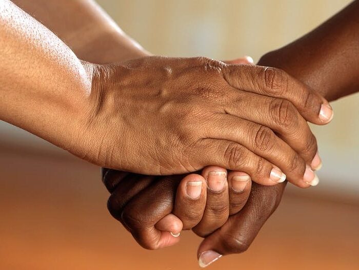 Pair of hands holding a third hand