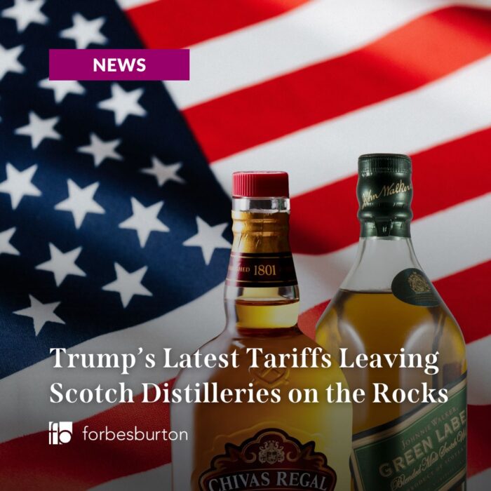 Scotch whisky bottles in front of American flag to symbolise Trump's tariffs