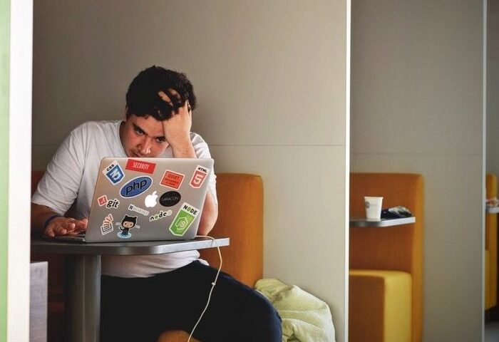 man looking stressed researching tax and hmrc on laptop